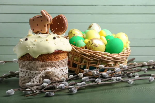 Weidenzweige Osterkuchen Und Korb Mit Bemalten Eiern Auf Grünem Holzgrund — Stockfoto