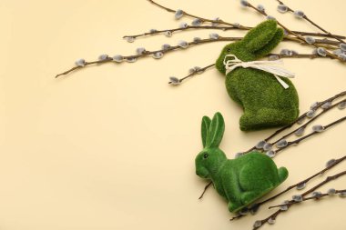 Sarı arka planda söğüt dalları ve Paskalya tavşanları