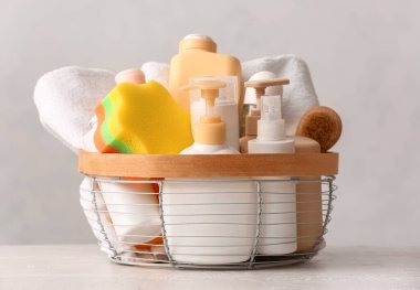 Hafif arka planda kozmetik ürünleri ve banyo aksesuarları olan sepet.