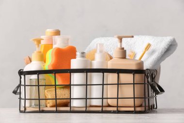Hafif arka planda kozmetik ürünleri ve banyo aksesuarları olan sepet.