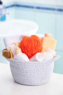 Kozmetik ürünleri ve banyo aksesuarlarıyla dolu bir sepet.