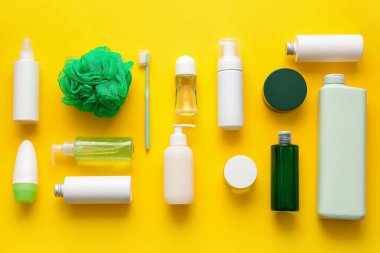 Kozmetik ürünleri, banyo süngeri ve sarı arka planda diş fırçası bileşimi