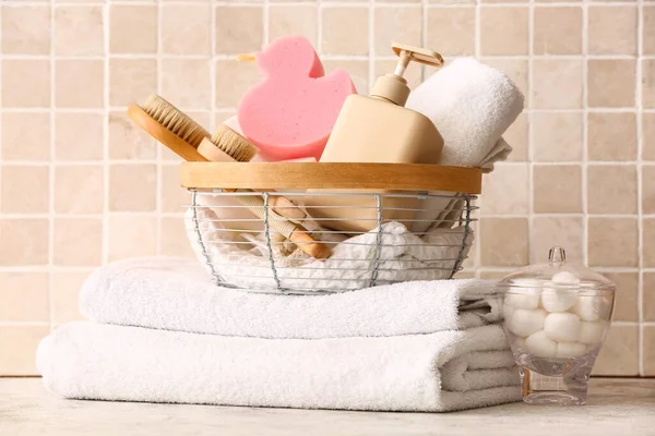 一堆堆干净的毛巾 棉球和篮子 桌上有洗浴用品 靠近彩色瓷砖 — 图库照片