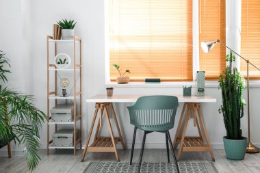 Modern işyeri ve ev bitkilerinin bulunduğu hafif bir ofis.
