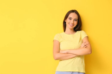 Sarı arka planda şık tişörtlü güzel bir bayan.