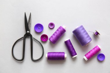 Makaslı iplik makaraları ve ışık arkaplanındaki düğmeler