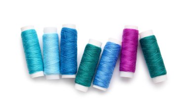 Beyaz arkaplanda farklı iplik makaraları