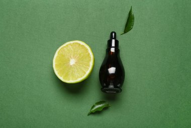 Şişe yağlı ve yeşil arka planda olgun bergamot meyvesi.