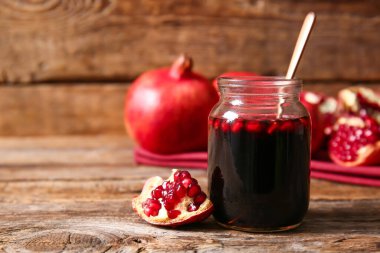 Ahşap zemin üzerinde bir kavanoz nar pekmezi.