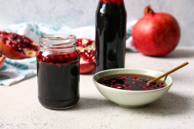 Kavanozlar ve bir kase nar pekmezi.