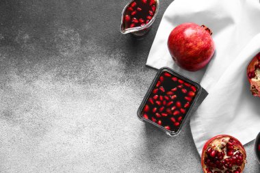 Arkaplanda bir kase nar pekmezi ve sos kabı.