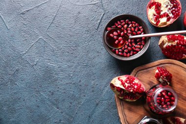 Kavanoz ve bir kase nar pekmezi ve siyah arka planda taze meyveler.