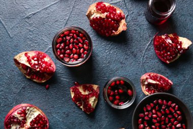 Kavanozlar dolusu nar pekmez ve siyah zemin üzerinde taze meyveler.