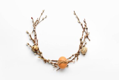 Paskalya yumurtaları ve hafif arka planda söğüt dalları olan şık bir çelenk.