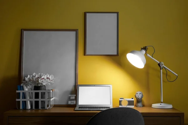 Modern Arbetsplats Med Laptop Arrangör Ramar Och Glödande Lampa Nära — Stockfoto