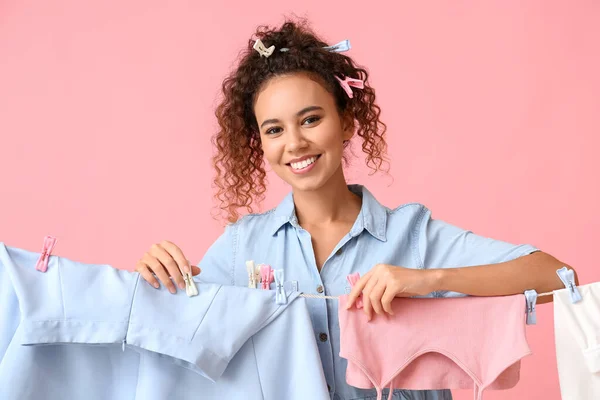 Young African American Woman Hanging Laundry Plastic Clothespins Pink Background — Stock Photo, Image