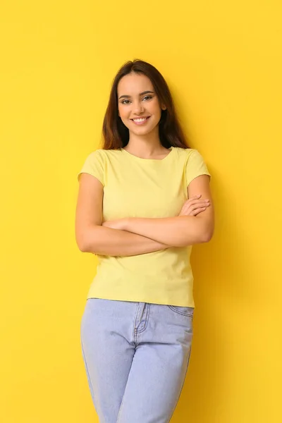 穿着黄色背景的时髦T恤的年轻漂亮女人 — 图库照片