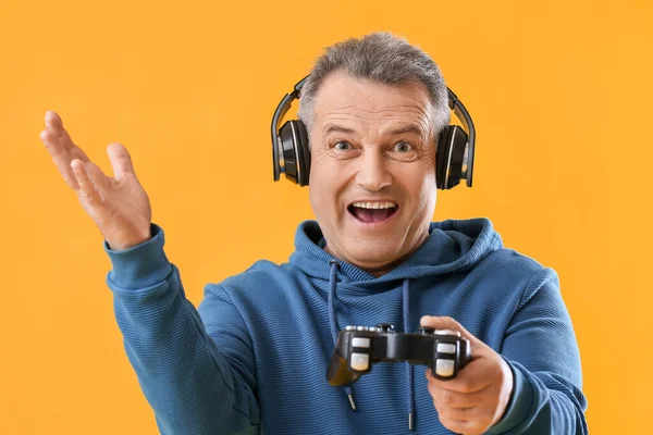 Hombre Mayor Feliz Auriculares Con Almohadilla Juego Sobre Fondo Amarillo —  Fotos de Stock