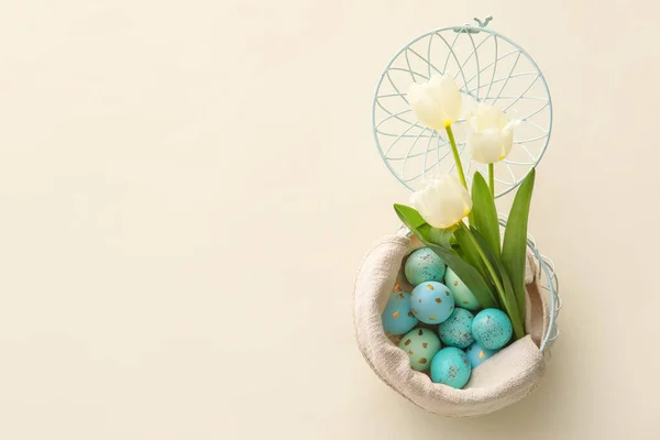 有彩绘复活节彩蛋和米色背景郁金香花的篮子 — 图库照片
