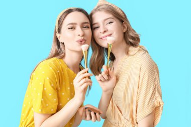 Makyaj fırçası ve makyaj malzemesi olan genç kız kardeşlerin portresi