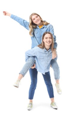 Beyaz arka planda mutlu genç kız kardeşlerin portresi