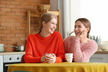 Evde çay içen genç kız kardeşler.