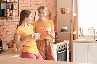 Evde çay içen genç kız kardeşler.