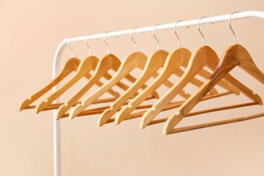 Ahşap elbiseli raflar açık arkaplanda asılı.