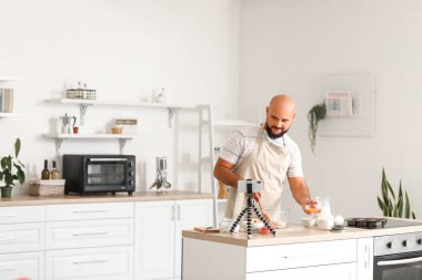 Mutfaktaki video dersinden hamuru ve sarı sarısı olan yakışıklı bir adam.