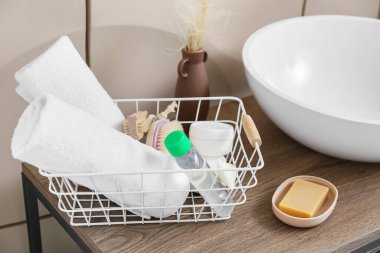 Lavabonun yanındaki sepetin içinde banyo malzemeleri var.