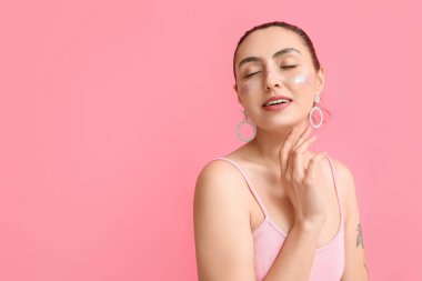 Yaratıcı makyajlı ve pembe arka planda kapalı gözlü bir kadın.