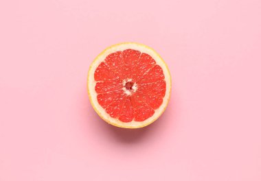 Pembe arka planda yarım greyfurt.