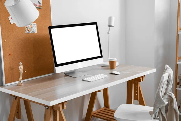 Interior of light office with modern workplace, computer and lamp