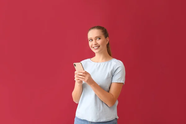 Mooie Jonge Vrouw Met Mobiele Telefoon Rode Achtergrond — Stockfoto