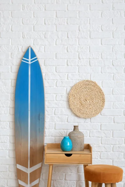 Table Avec Vases Pouf Planche Surf Près Mur Briques Blanches — Photo