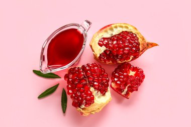 Lezzetli olgun nar parçaları ve pembe arka planda reçelli et suyu teknesi.