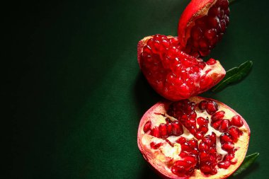 Koyu yeşil arka planda olgun nar parçaları.