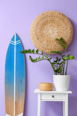 Sörf tahtası ve renkli duvarın yanındaki masa.