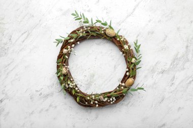 Paskalya çelengi, okaliptüs dalları, çigila çiçekleri ve açık arkaplanda yumurtalar.