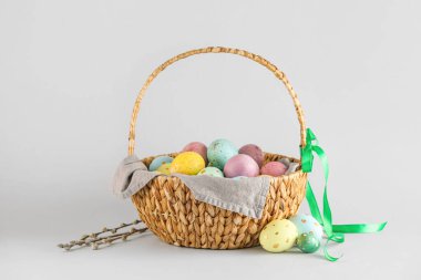 Açık arkaplanda boyanmış Paskalya yumurtaları sepeti