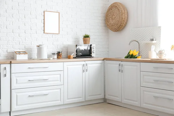 白砖墙附近有不同器皿和郁金香水槽的厨房柜台 — 图库照片
