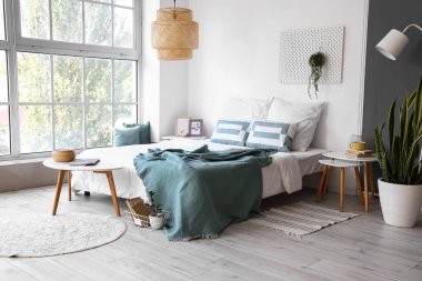 Yatak odasının içi komodinli ve büyük pencereli.