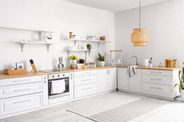 Aydınlık mutfağın içinde farklı aletler, çiçekli vazo ve Paskalya dekorasyonu.