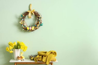 Güzel laleli masa, örgü süveterler ve renkli duvarın yanında Paskalya dekoru.