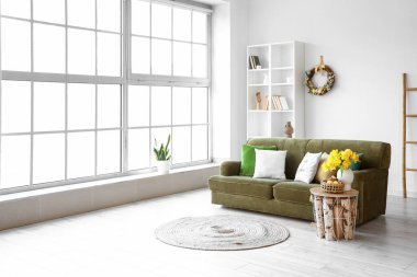 Koltuk, raf ünitesi ve Paskalya çelengi oturma odasının iç tarafındaki aydınlık duvarda.