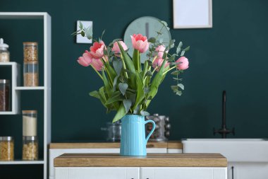 Mutfak tezgahında siyah arka planda güzel çiçekli sürahi.