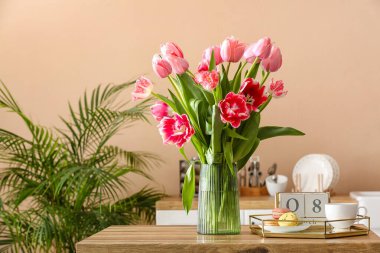 Güzel laleler, makaronlu tepsi, fincan ve küp takvim. Mutfaktaki masada 8 Mart tarihli. Uluslararası Kadınlar Günü kutlamaları