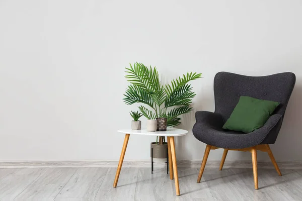 Sillón Moderno Con Mesa Plantas Cerca Pared Luz —  Fotos de Stock