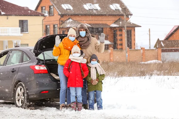 冬の雪の日に車の近くの医療マスクの家族 — ストック写真