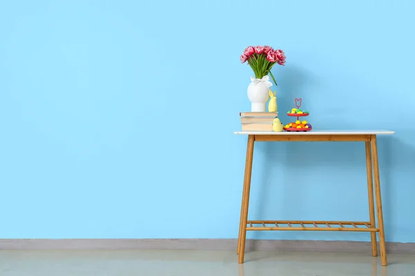 Ваза Тюльпанами Книгами Декором Пасхальными Яйцами Столе Голубой Стены — стоковое фото